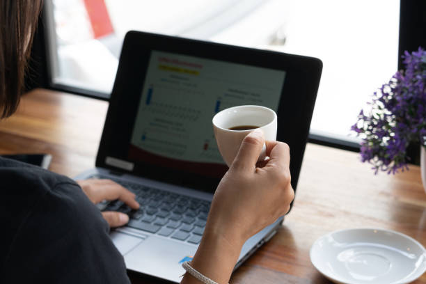 istock lady drinking coffee and working  on laptop in coffee shop 998366608