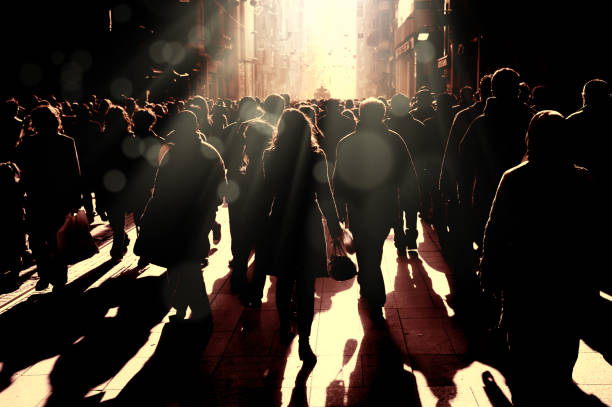 Large group of silhouetted people walking on busy street Close up image of crowded people walking on busy street in Istanbul, Turkey bustling city stock pictures, royalty-free photos & images