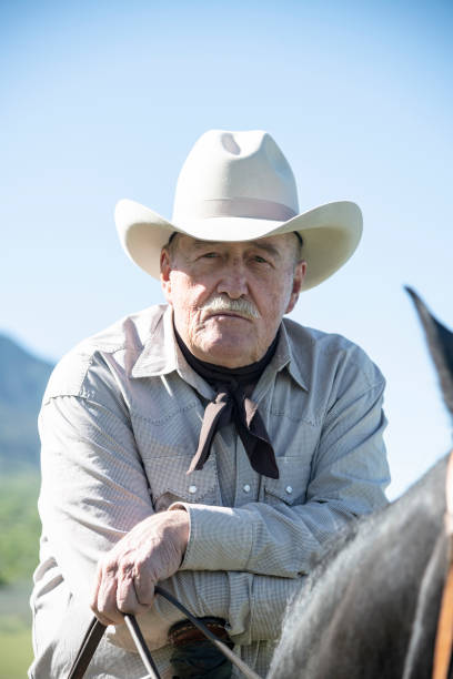 istock Serious senior cowboy on horse facing camera 998373856