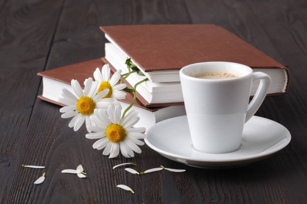 istock book and daisie flower on wooden table 998373958