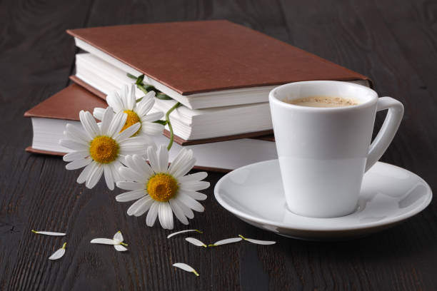 istock Stack of books with small bunch of daisies 998373982