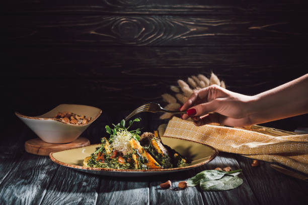 istock cropped image of woman eating panikesh with cashew nuts and spinach by fork over table 998380136