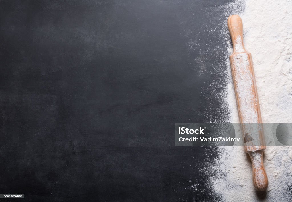 Baking background with copy space on black surface for your text. Top view. Baking background with copy space on black surface for your text. Top view. Flour is a traditional ingredient for breadmaking and other baking. Often used in Italian, Arabic and Chinese cuisines Flour Stock Photo