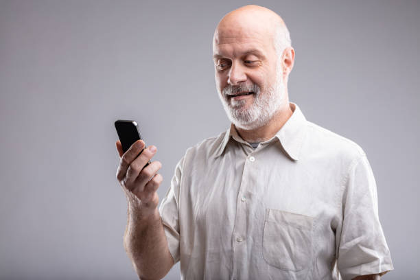 mature man looking satisfied his smartphone and the internet of things