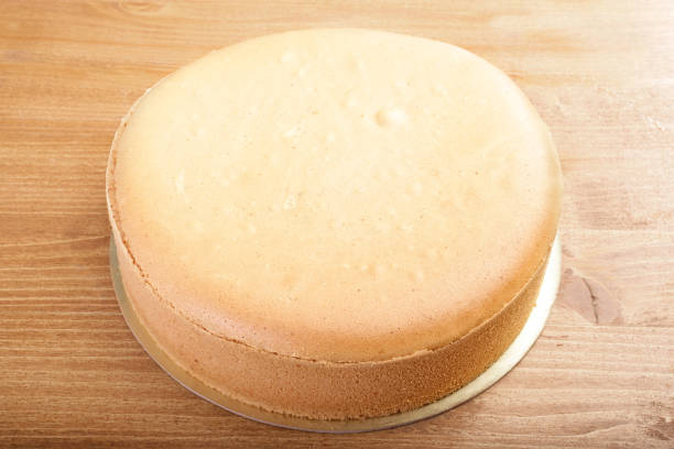 istock Close up fresh plain sponge cake on wooden table 998407984