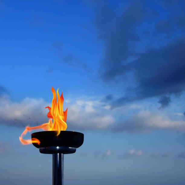 istock Close up burning flaming torch over cloudy sky 998410552