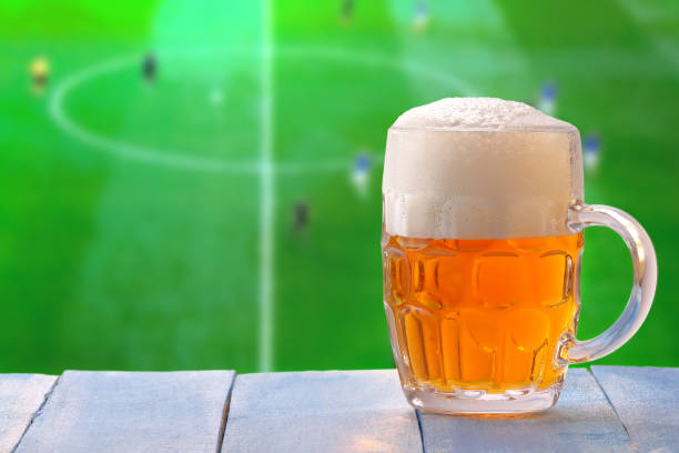Beer glass with foam and against tv background