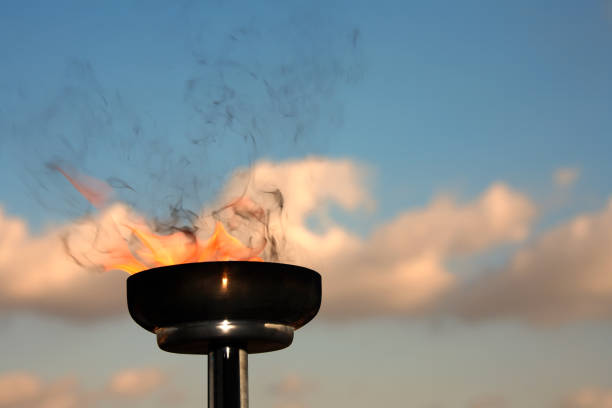 istock Close up burning flaming torch over cloudy sky 998410682