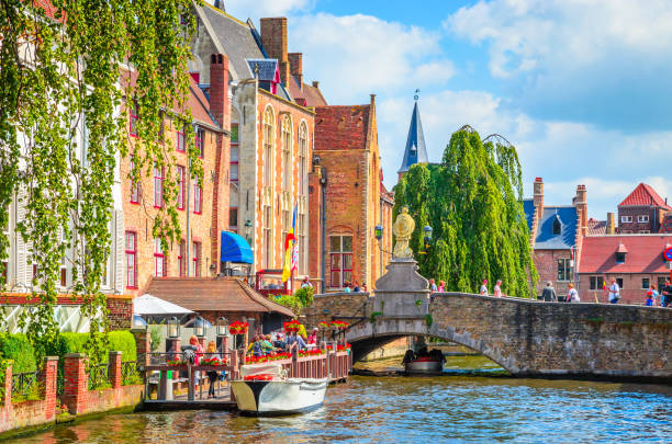 lindo canal e casas tradicionais na velha cidade de bruges (brugge), bélgica - bruges belgium history scenics - fotografias e filmes do acervo