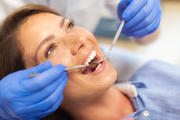 istock Female dentist examinining patient's teeth 998411568