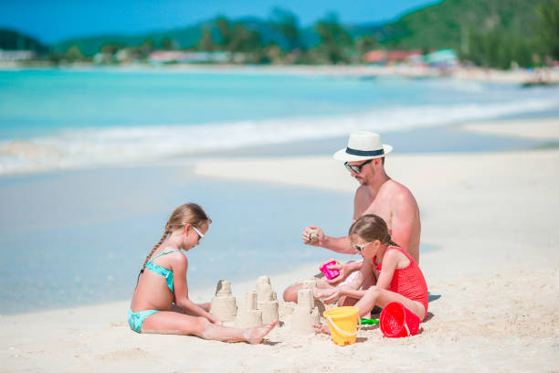 istock Family making sand castle at tropical white beach 998416176