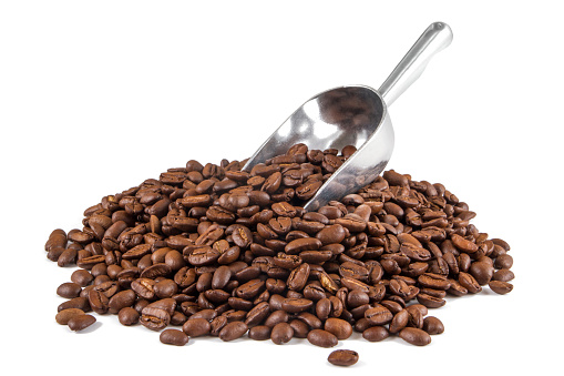 Roasted coffee beans in scoop on white background