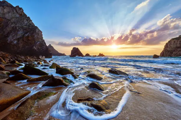 Photo of Sand beach among rocks on evening sunset