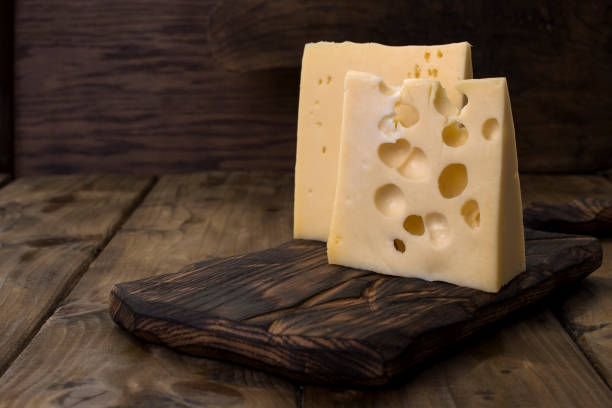 a beautiful swiss cheese with holes, a useful dairy product. tasty food. country style photo. place for text. copy space - cheese emmental cheese switzerland grated imagens e fotografias de stock