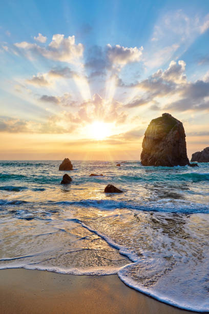 istock Sand beach among rocks on evening sunset 998425578