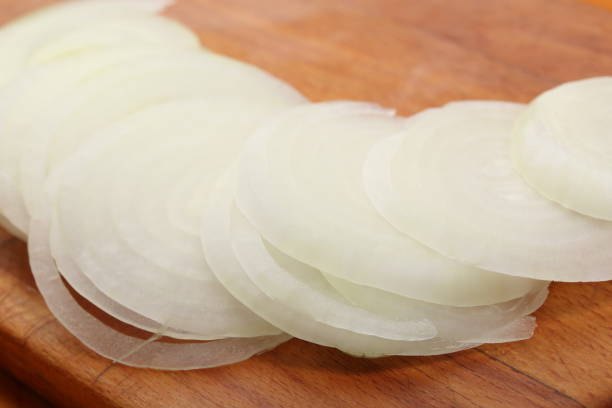 istock Sliced onions lie on a wooden cutting board. Selective focus 998425944