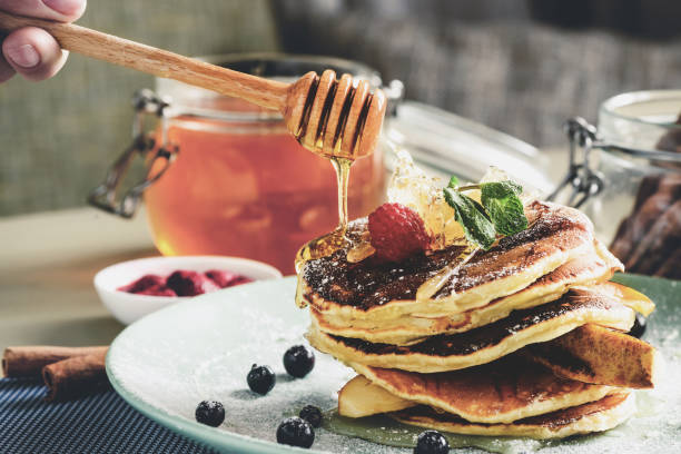 istock Process of preparing delicious pancakes with honey and berries, 998428704