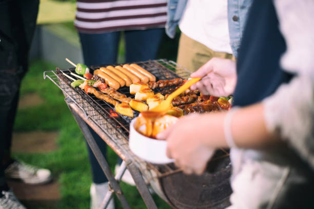 istock Midsection Of People Standing By Barbecue Grill At Yard 998428942