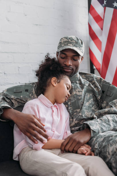 istock Army soldier father looking at his sleepy daugher 998429090
