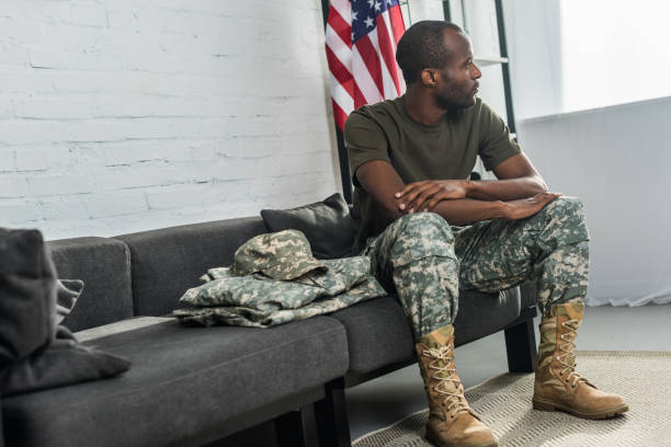istock Handsome male soldier sitting on sofa with camouflage clothes 998429354