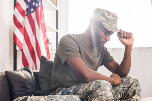 istock African american soldier in camouflage clothes sitting on sofa 998429360