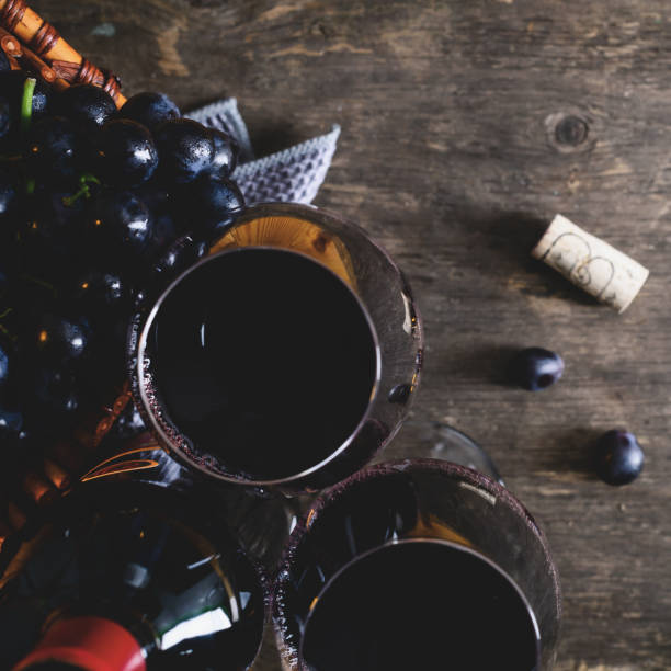 istock Still life with two full wineglasses, bottle of red wine and gra 998429450