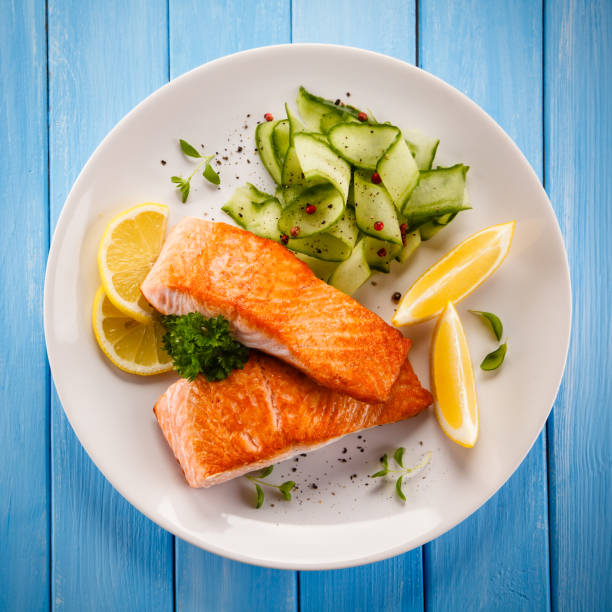 istock Grilled salmon with vegetables on wooden table 998435988