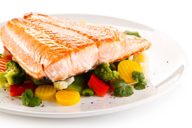 istock Grilled salmon with vegetables on wooden table 998436272