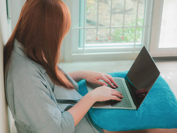 작업 온라인 및 홈 오피스 개념 회색 비즈니스 정장에 긴 갈색 머리 아시아 여자에서 바닥에 앉아서 그녀의 집에 사무실에서 노트북을 사용 하 여 - women computer home interior brown hair 뉴스 사진 이미지