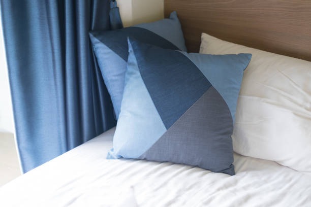 istock Blue pillows on sheets bed with blue curtain. Vacation concept with hotel apartment interior. 998444586