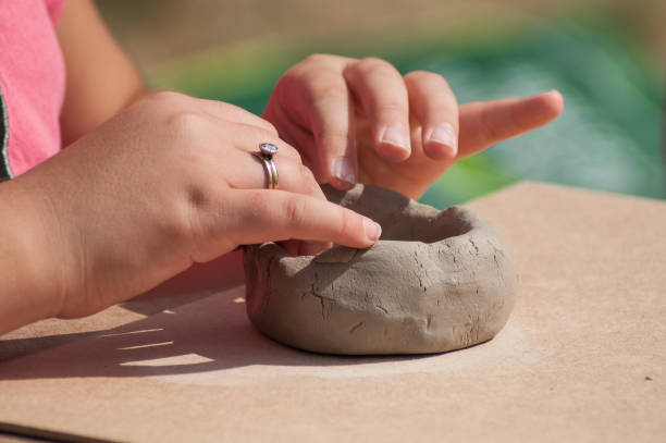 屋外で粘土陶器ボウルを作る子供の手 - natural form ストックフォトと画像