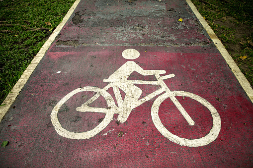 Conceptual image of close up bicycle sign on public park road