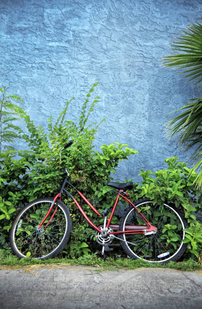 zamknij czerwony rower przez ścianę budynku - bicycle wall green single object zdjęcia i obrazy z banku zdjęć