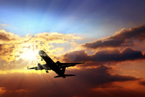 istock Close up flying commercial passenger airplane over sunset 998468444