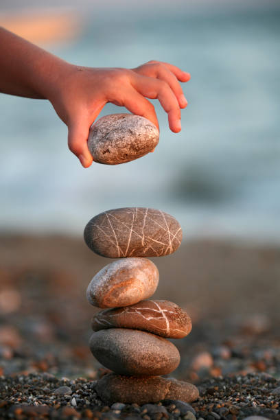 istock Little girl playing with stones on beach 998477304