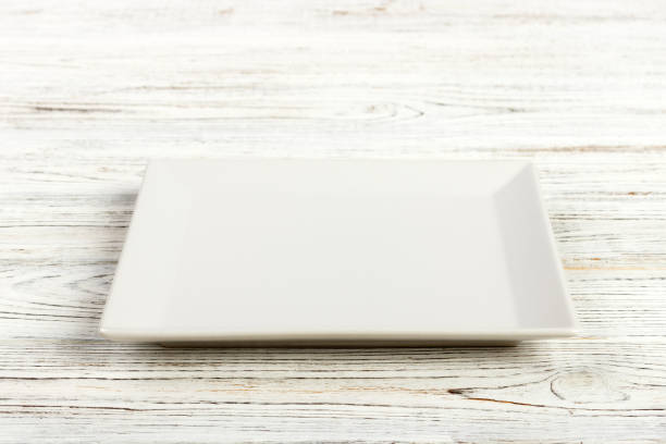 istock Perspective view. white square plate on a wooden table 998478062