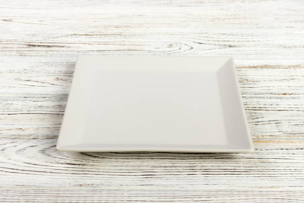 istock Perspective view A square plate on the white wooden table 998478074