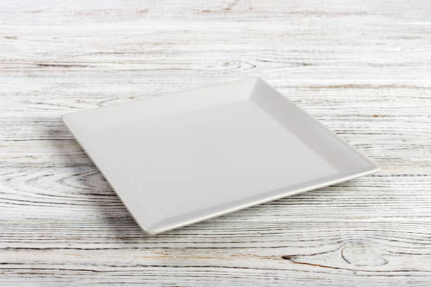 istock Perspective view. white square plate on a wooden table 998478082