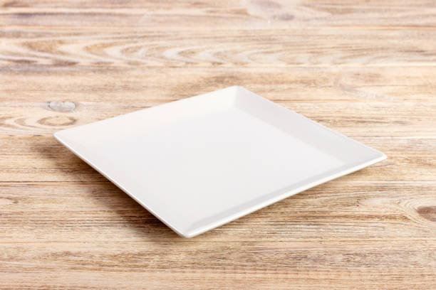 istock Perspective view. white square plate on a wooden table 998478166