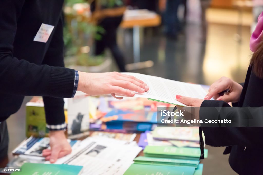 Man and Woman Sharing Information Leaflet over Exhibition Stand Tradeshow Stock Photo