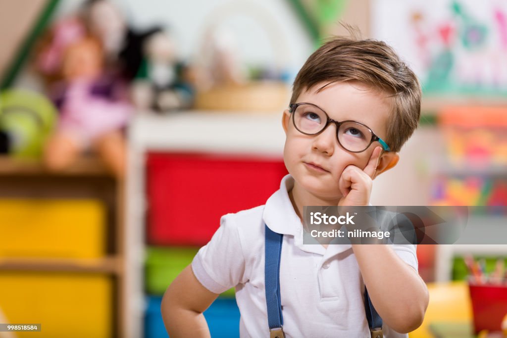 Preschooler Little boy planning in classroom. Child Stock Photo