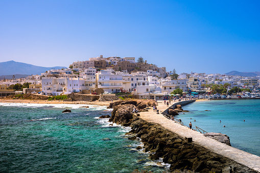 Chora of Naxos island as seen from the famous landmark the Portara with the natural stone walkway towards the village, Cyclades, Greece.