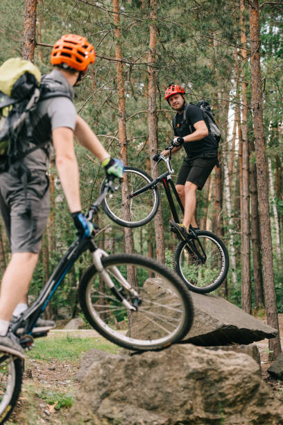 istock young men riding on trial bicycles at beautiful forest 998545742