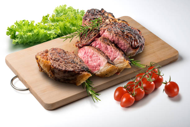 istock Fiorentina T-bone steak cut on rectangular wooden chopping board and vegetables 998552562