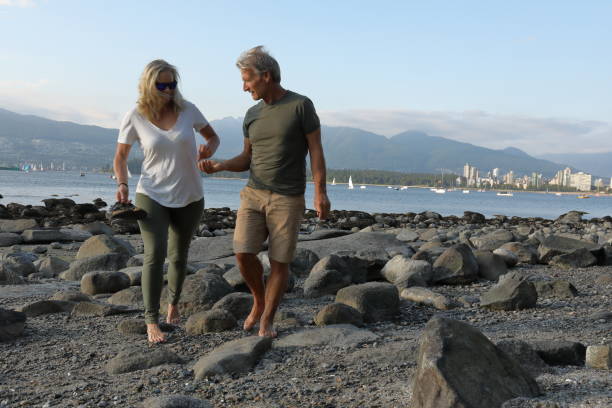 istock Couple walk along beach, tidal zone 998598988