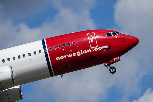 Arlanda, Stockholm, Sweden - July 10, 2018: Norwegian Air Shuttle ASA, Boeing 737 - 800 take off in white clouds and blue sky at Stockholm Arlanda Airport / ARN. Jet aircraft / plane.