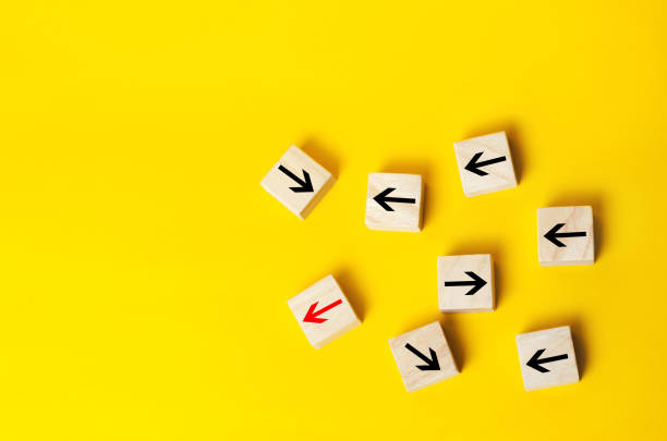 istock Wooden blocks with red arrow facing the opposite direction black arrows, Unique, dissenting opinion, individual and standing out from the crowd. divergent views 998629550