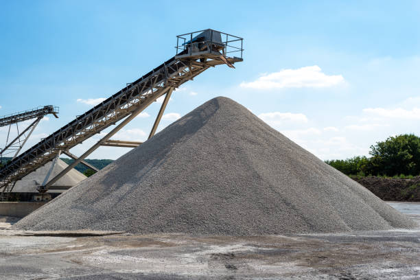 Conveyor over heaps of gravel on blue sky at an industrial cement plant. Conveyor over heaps of gravel on blue sky at an industrial cement plant. sand mine stock pictures, royalty-free photos & images