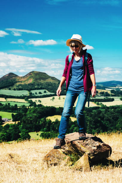 istock Active senior woman walking on a grass meadow 998643952