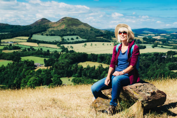 istock Active senior woman walking on a grass meadow 998654852